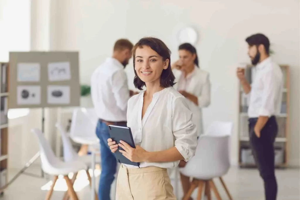 Il s'agit d'une femme dans un bureau avec le sourire