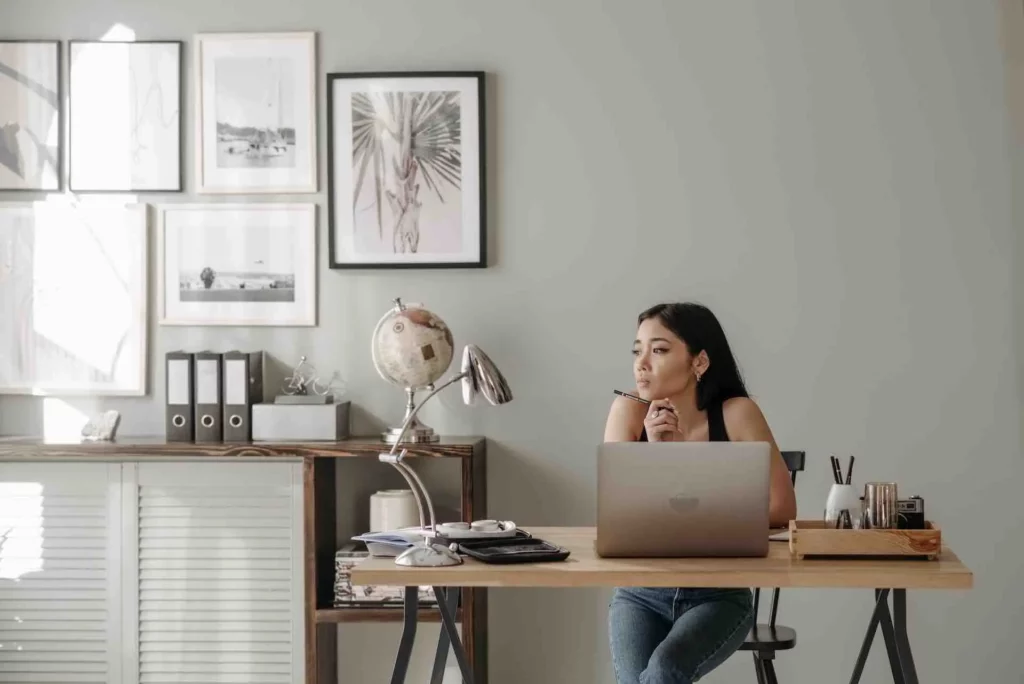 Il s'agit d'une femme à son bureau qui réfléchie