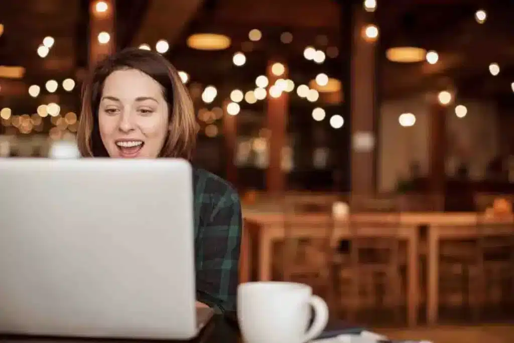 une personne est devant son ordinateur dans un café 