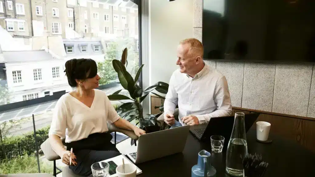 Un homme et une femme discute autour d'un bureau