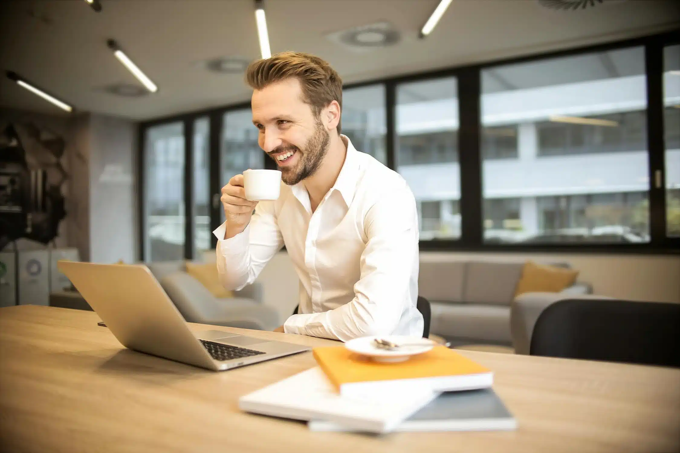 Un homme souriant qui travail seul dans son bureau.