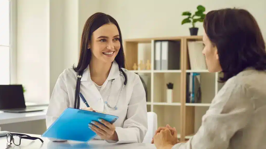 Une femme travaille dans le secteur de la santé. Elle est dans son bureau avec une femme, elles discutent.