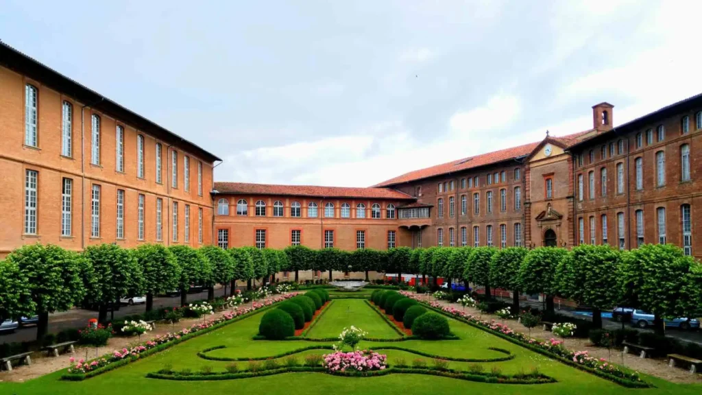 Un bâtiment de Toulouse avec un grand jardin vert.