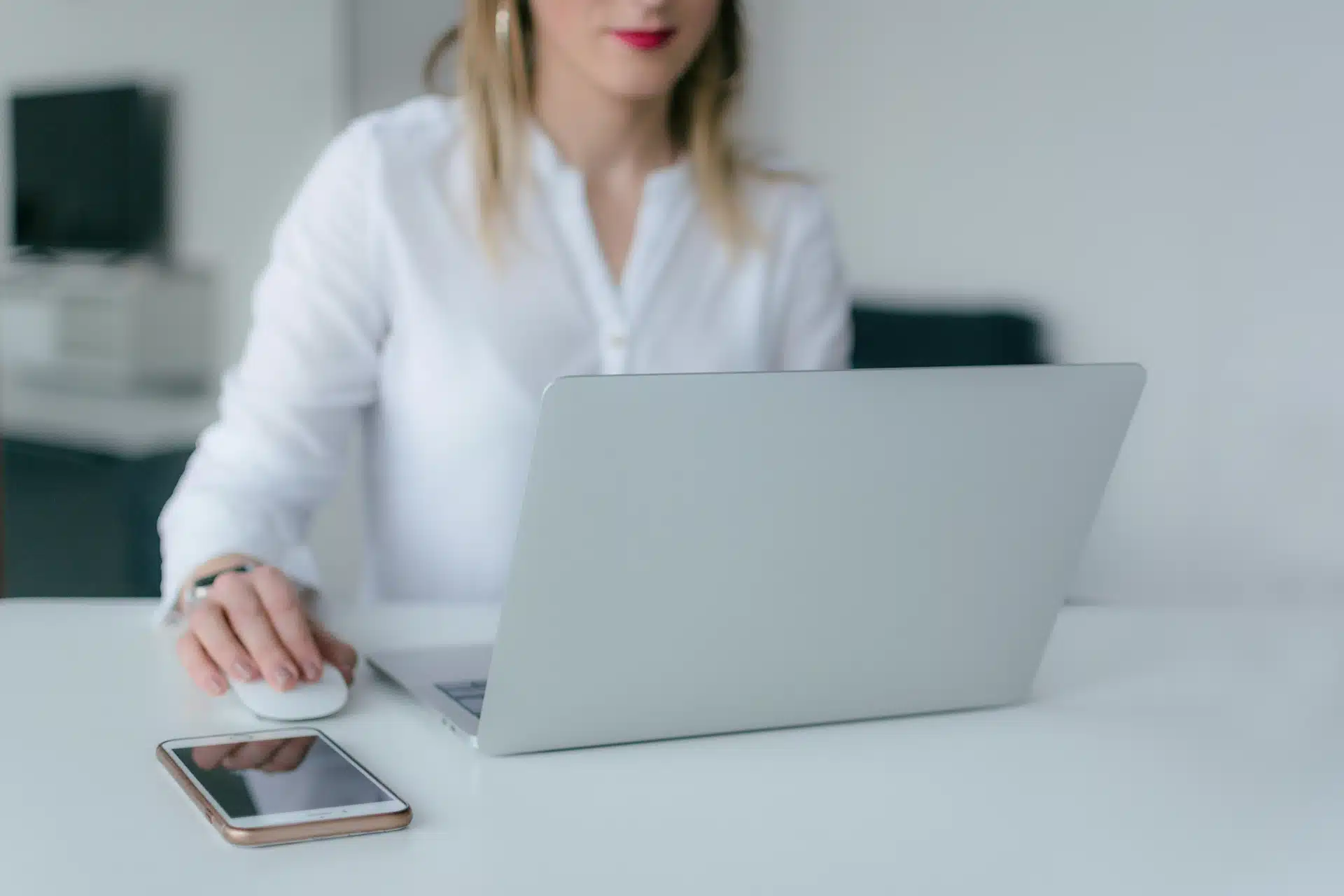 Une femme derrière son ordinateur. Elle utilise les meilleures outils de communication.