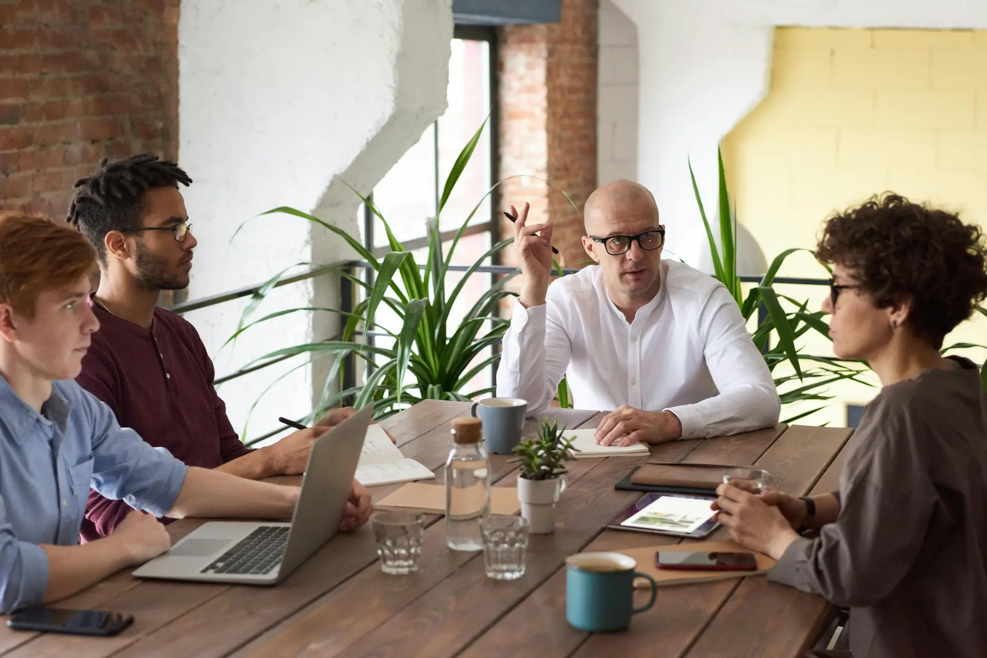 5 personnes optimisent leur communication autour d'une table