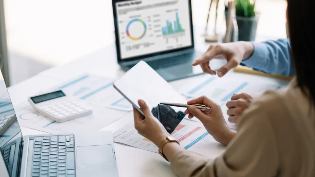 Un chef de projet analyse des données à partir de différents documents papier.