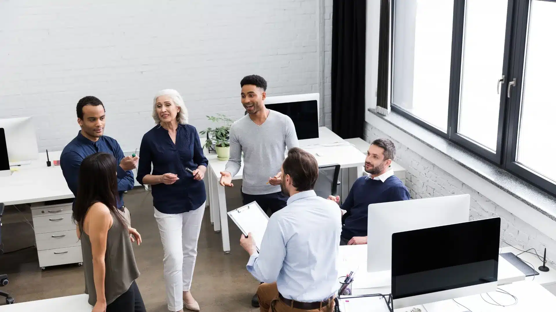 Une équipe discute avec un manager opérationnel dans un bureau.