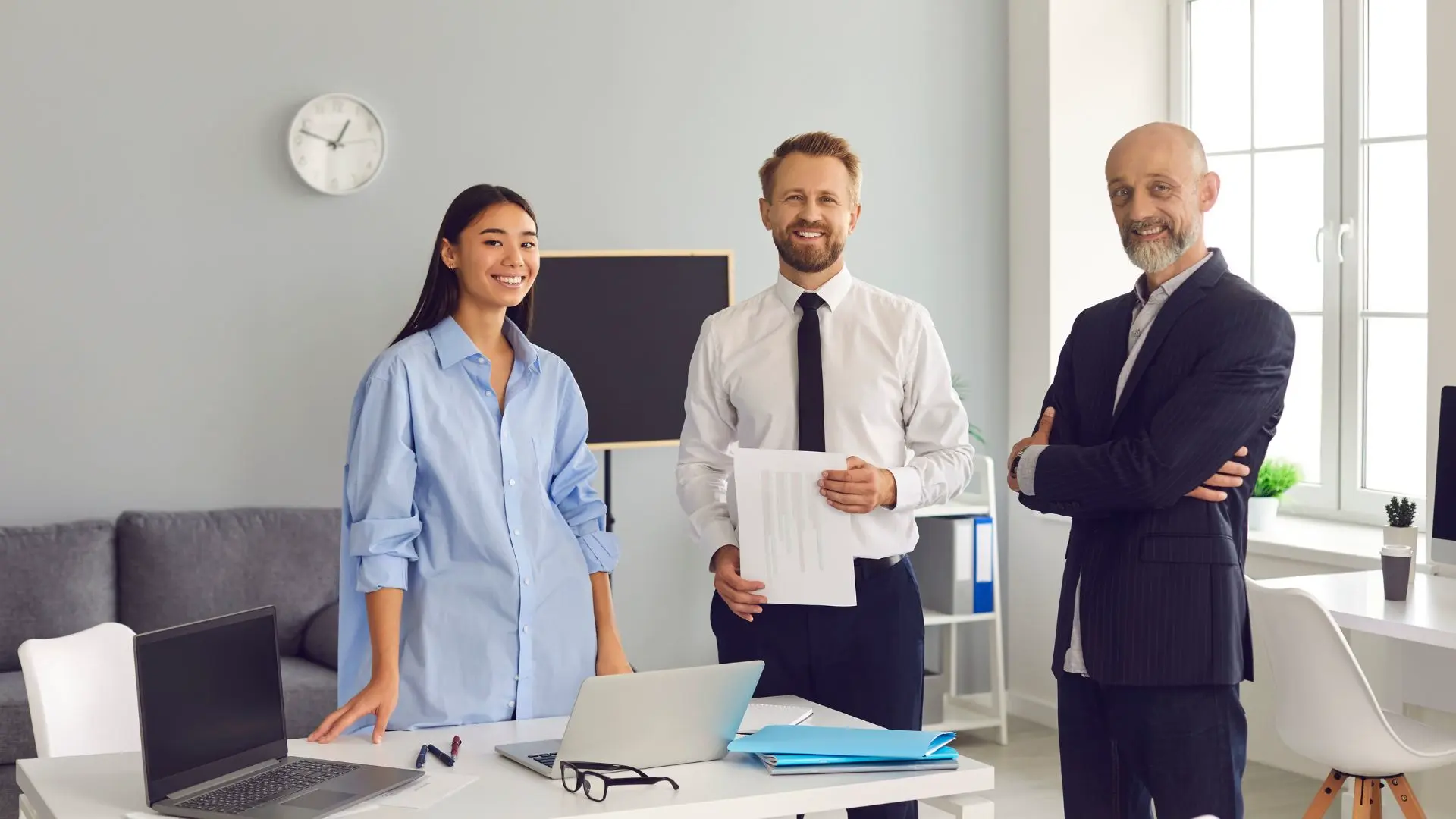 Trois personnes sont dans un bureau. Il y a un responsable de département.