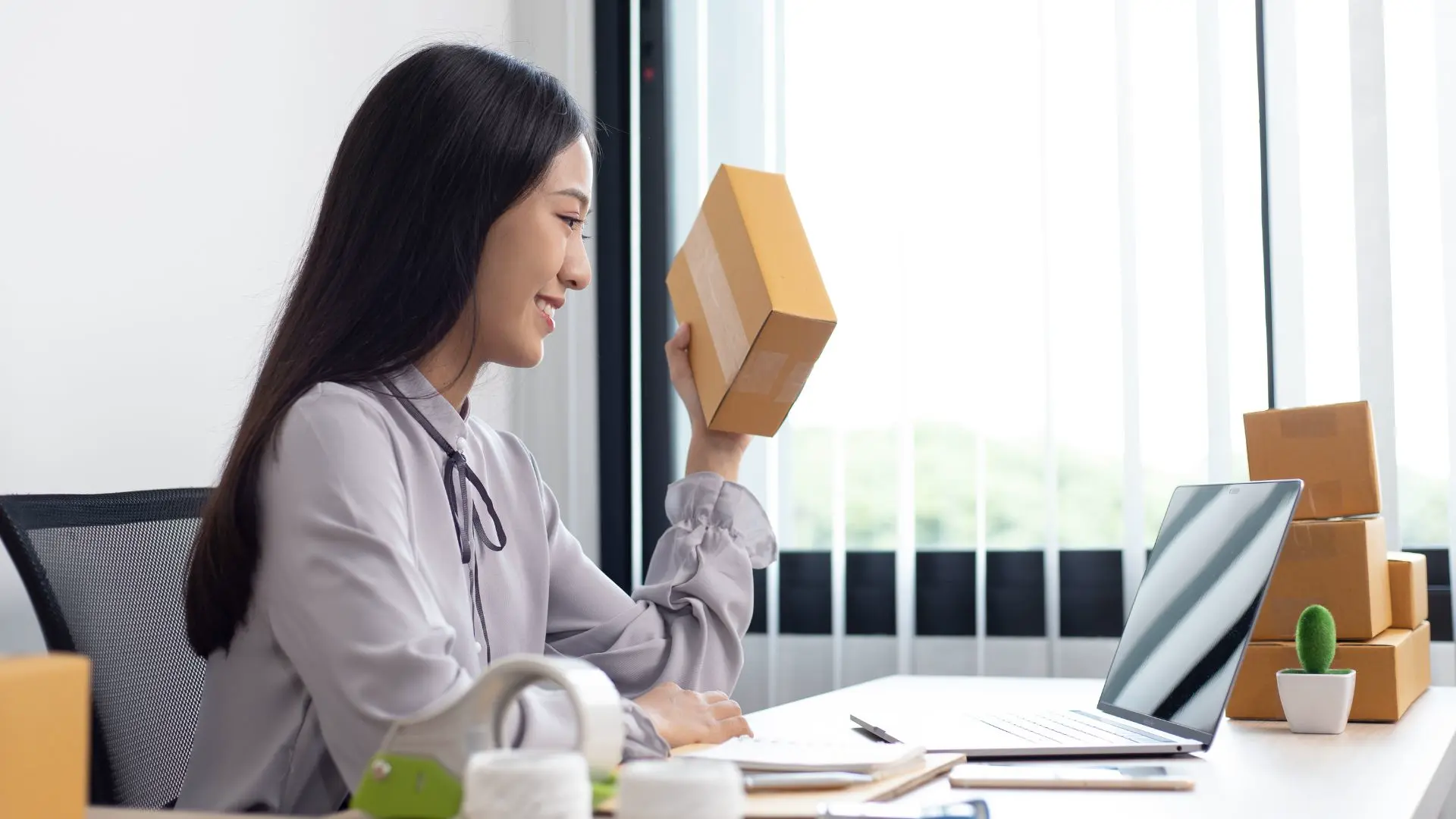 Une responsable des ventes s'occupe des ventes en ligne depuis son ordinateur.